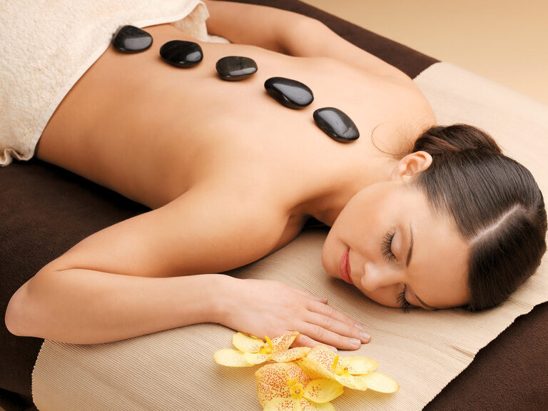 Frau erhält eine Hot-Stone-Massage im Wellnessbereich des Hotel zum goldenen Anker