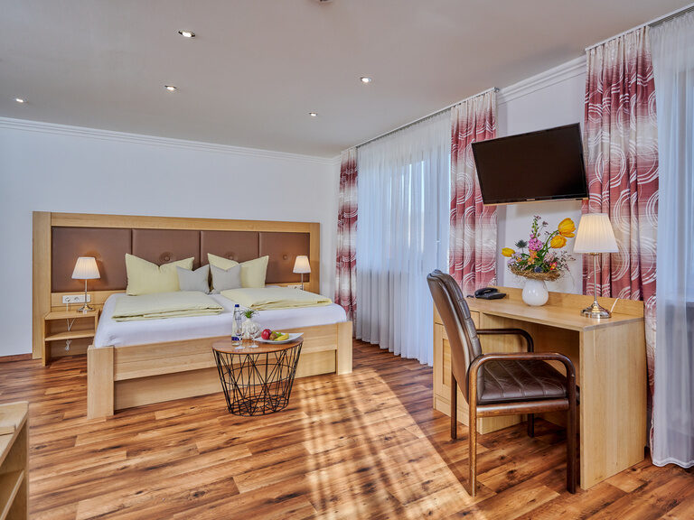 Hotelzimmer mit Doppelbett, Schreibtisch und Holzboden im Hotel zum goldenen Anker