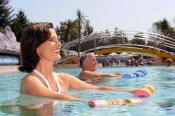 Eine Gruppe von Menschen während der Durchführung von Wassergymnastikübungen im Pool der Johannesbad Therme Bad Füssing.