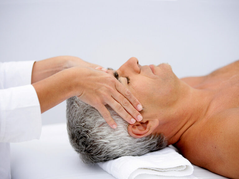 Mann erhält eine entspannende Kopfmassage im Wellnessbereich des Hotel zum goldenen Anker