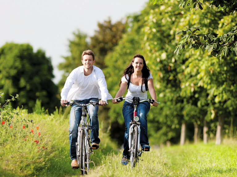 Paar fährt gemeinsam mit dem Fahrrad durch die Natur in der Umgebung des Hotel zum goldenen Anker