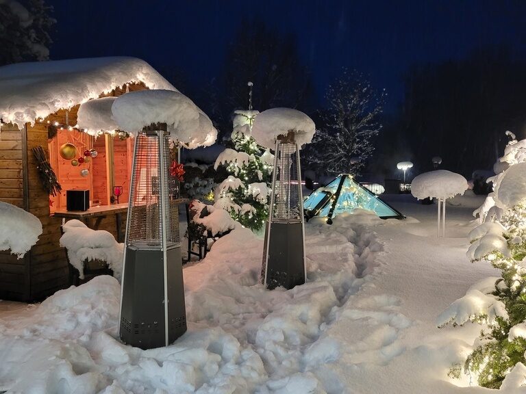 Verschneiter Vorplatz eines Hotels in einer frostigen Winternacht.
