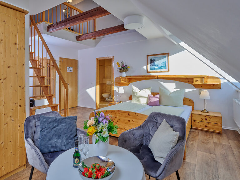 Ein liebevoll eingerichtetes Wohnzimmer mit Galerie in der Doppelzimmer Donau im Hotel Zum Goldenen Anker.